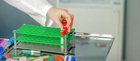 Technician puts test tube to rack photo