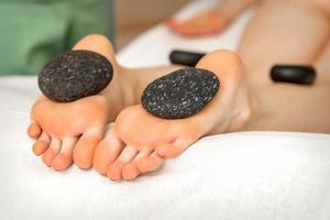 Massage stones on soles feet photo