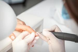 Manicure master removes nail polish photo