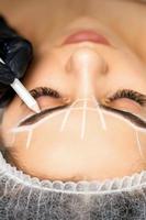 Beautician marking eyebrows with pencil photo