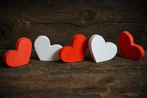 Red and white hearts on old shabby wooden background photo