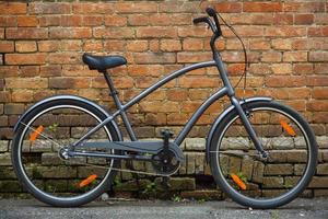 Black retro vintage bicycle with brick wall photo