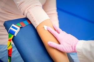 Nurse applying cotton swab to arm photo