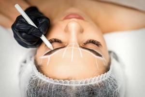 Beautician marking eyebrows with pencil photo