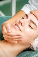 Young woman getting facial massage photo