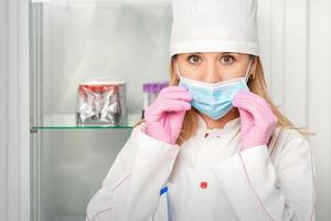 Nurse putting on medical face mask photo