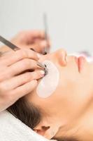 Woman having eyelash extension procedure photo