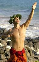 A hula dancer who is male is using his hands to gesture traditional Hawaiian symbols. photo