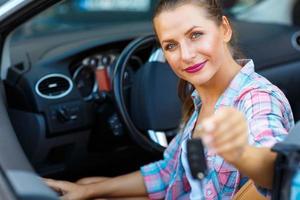 joven bonito mujer sentado en un convertible coche con el llaves en mano foto