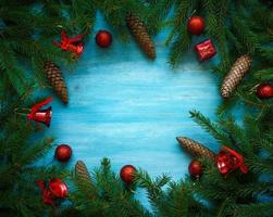 Christmas tree branches with cones and christmas decorations on blue wooden texture ready for your design photo