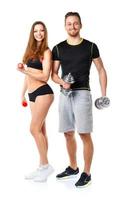 Athletic man and woman with dumbbells on the white photo