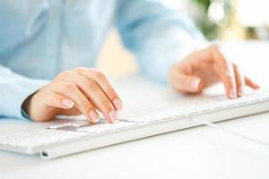 Woman office worker typing on the keyboard photo