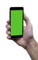 Male hand holding black cellphone with green screen at isolated white background. photo