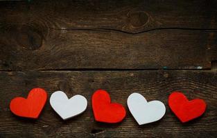 Red and white hearts on old shabby wooden background photo