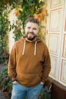 Outdoor portrait of young handsome smiling curly hair style man with beard in spring season photo