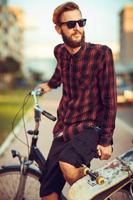 Man in sunglasses riding a bike on city street photo