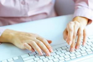 Woman office worker typing on the keyboard photo