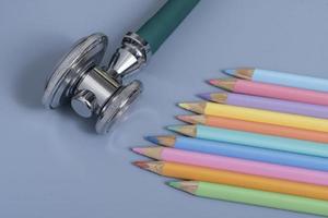 Sample of colored pencils and a stethoscope representing the pediatric doctor photo