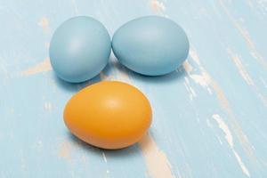 Eggs symbolizing the Easter holiday in blue and orange color on a background of aged wood photo