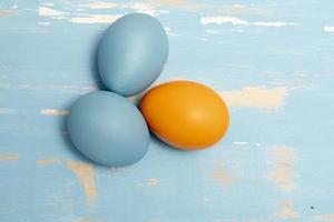 Eggs symbolizing the Easter holiday in blue and orange color on a background of aged wood photo