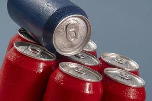 Cold red soda cans with a blue one for conceptual use photo