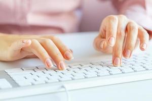 Woman office worker typing on the keyboard photo