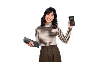 Portrait of young Asian woman casual uniform holding white piggy bank and notebook isolated on white background. Financial and bank saving money concept photo