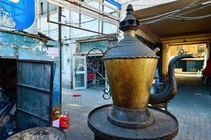 A trash dump and oversized Uyghur teapot landmark inside a traditional market in Urumqi, Xinjiang, China photo