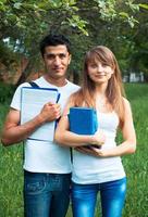 dos estudiantes en parque con libro al aire libre foto