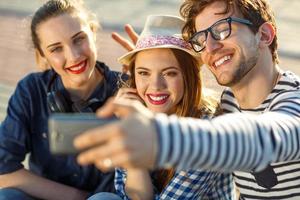 Smiling friends making selfie outdoors photo