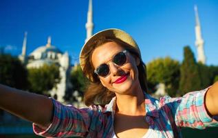 Girl making selfie by the smartphone on the background of the Blue Mosque, Istanbul. Turkey photo