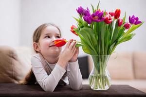 Little girl with spring tulip bouquet.  Holiday decor with flowers colorful tulips. photo