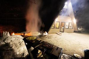 Wood fired barbecue against triangle country house at night. photo