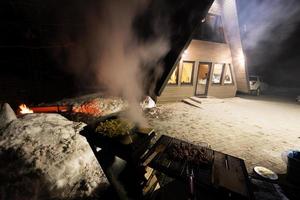 Wood fired barbecue against triangle country house at night. photo