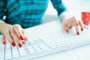 Woman office worker typing on the keyboard photo