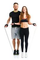 Happy athletic couple - man and woman with with ropes on the white photo