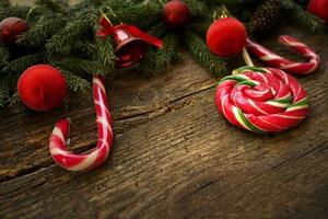 Christmas border with fir tree branches, cones, christmas decorations and candy canes photo