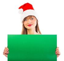 sonriente Navidad niña con verde cartel en blanco foto