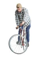 joven hombre haciendo trucos en fijo engranaje bicicleta en un blanco foto