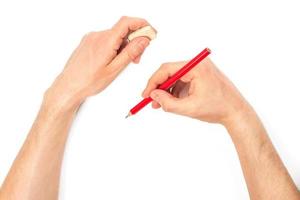 humano manos con lápiz y borrar caucho escribiendo alguna cosa foto