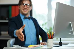 Young business man with arm extended to handshake photo