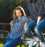 dos juguetón muchachas teniendo divertido al aire libre a puesta de sol ligero foto