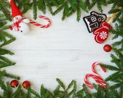 Navidad frontera con abeto árbol sucursales, Navidad decoraciones y caramelo caña en blanco de madera tableros foto