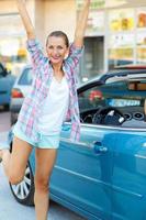 Young happy woman enjoys buying convertible photo