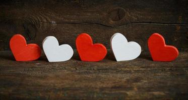 Red and white hearts on old wooden background photo