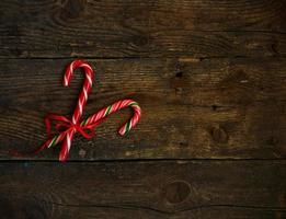 Closeup of two old fashioned candy canes on a rustic wooden background photo