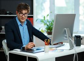 Handsome young man working from home office photo