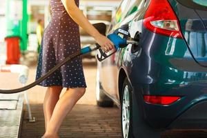 Woman fills petrol into her car photo