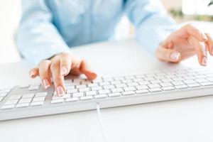 Woman office worker typing on the keyboard photo