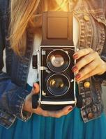 Summer lifestyle portrait of hipster girl with old camera photo